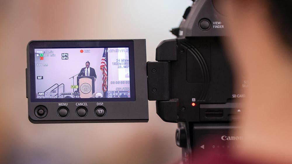 focus-on-film_spring2025-home Blurred closeup of a person on a video camera focus on the camera screen
